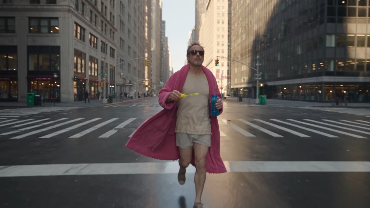 Round trolley following · 360° cinematic preview: orbiting a man in a pink bathrobe walking through a city